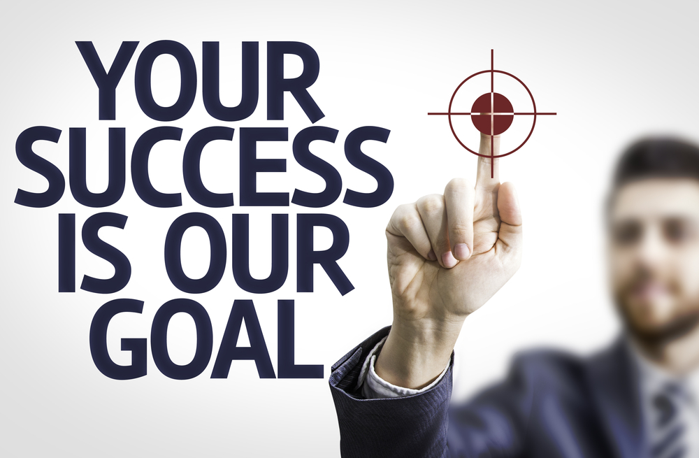 Business man pointing to transparent board with text Your Success Is Our Goal